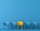 Image of blue chairs against a blue background, but in the middle is a yellow chair.