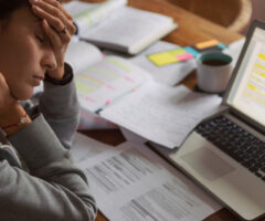 worker with hand on head in front of a computer