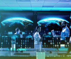 A high-tech operations center with multiple computer workstations and large screens displaying a digital rendering of Earth. A diverse team of cybersecurity or intelligence professionals, dressed in business casual attire, is engaged in discussion and analysis. The image has a futuristic overlay of binary code (1s and 0s), symbolizing data processing and cyber intelligence.