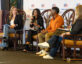 Four panelists sit on stage at ClearanceJobs Connect 2025 West in San Diego, engaged in a discussion about scalable recruiting. A branded backdrop and event signage are visible behind them, with microphones in hand and attentive expressions as they speak to the audience.